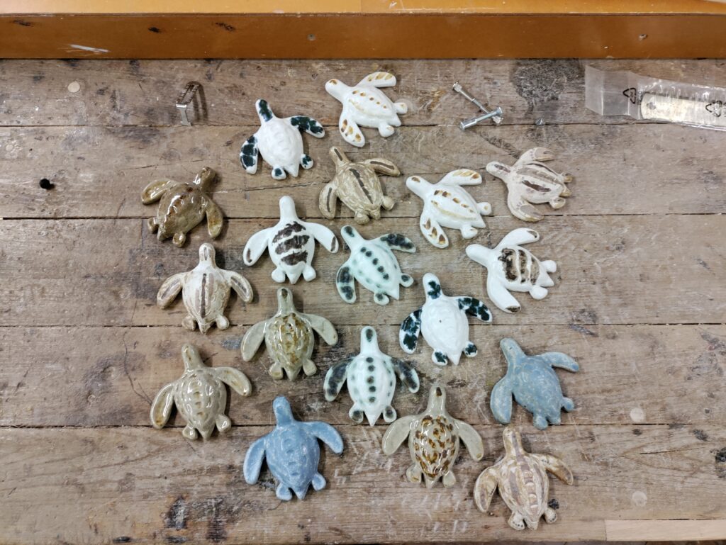 Ceramic turtles on sand and wood